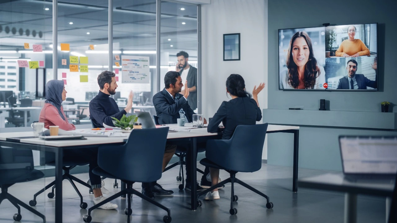videoconferencia con 4 personas en oficina y 3 en pantalla