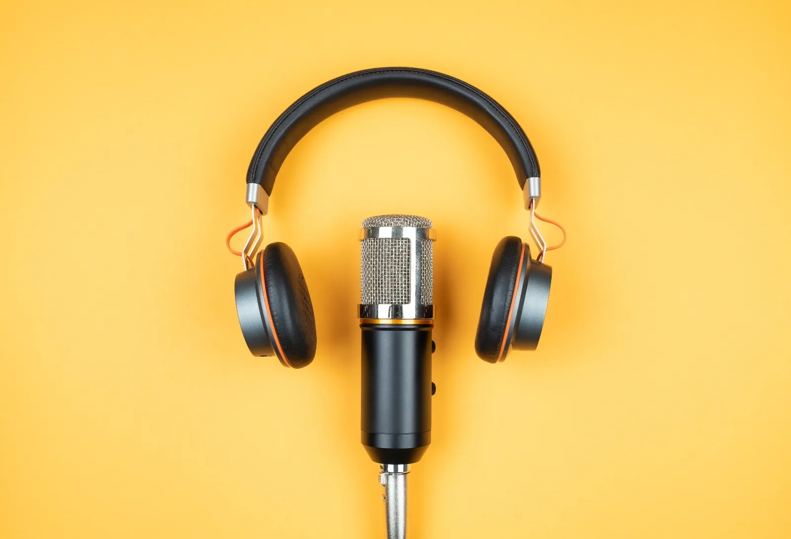 micrófono sobre mesa amarilla con audífonos