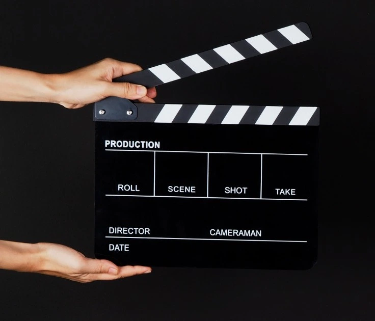Dos manos sostienen el uso de la pizarra de películas o de la tabla de Clapperboard en la producción de video